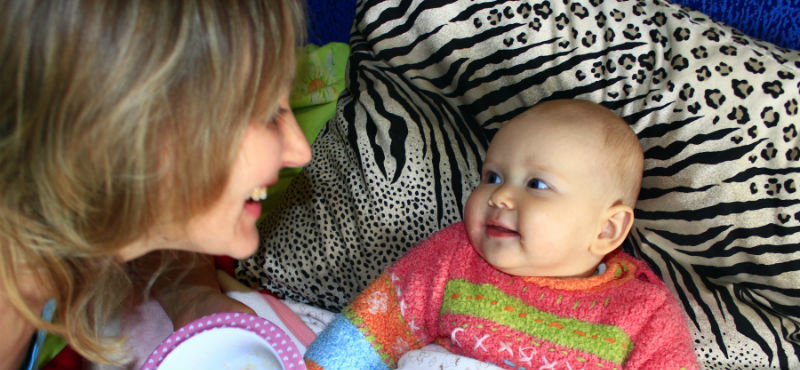 Kvinna ler mot bebis 