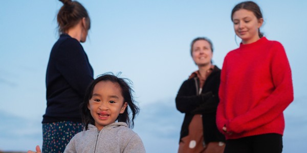 Barn i fokus med familj i bakgrunden. Foto Lo Birgersson